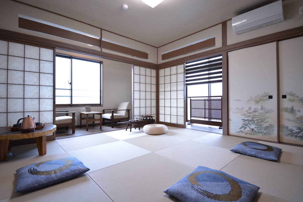 Een traditionele Japanse kamer met tatami vloeren, schuifdeuren en een theesetje op een lage tafel.