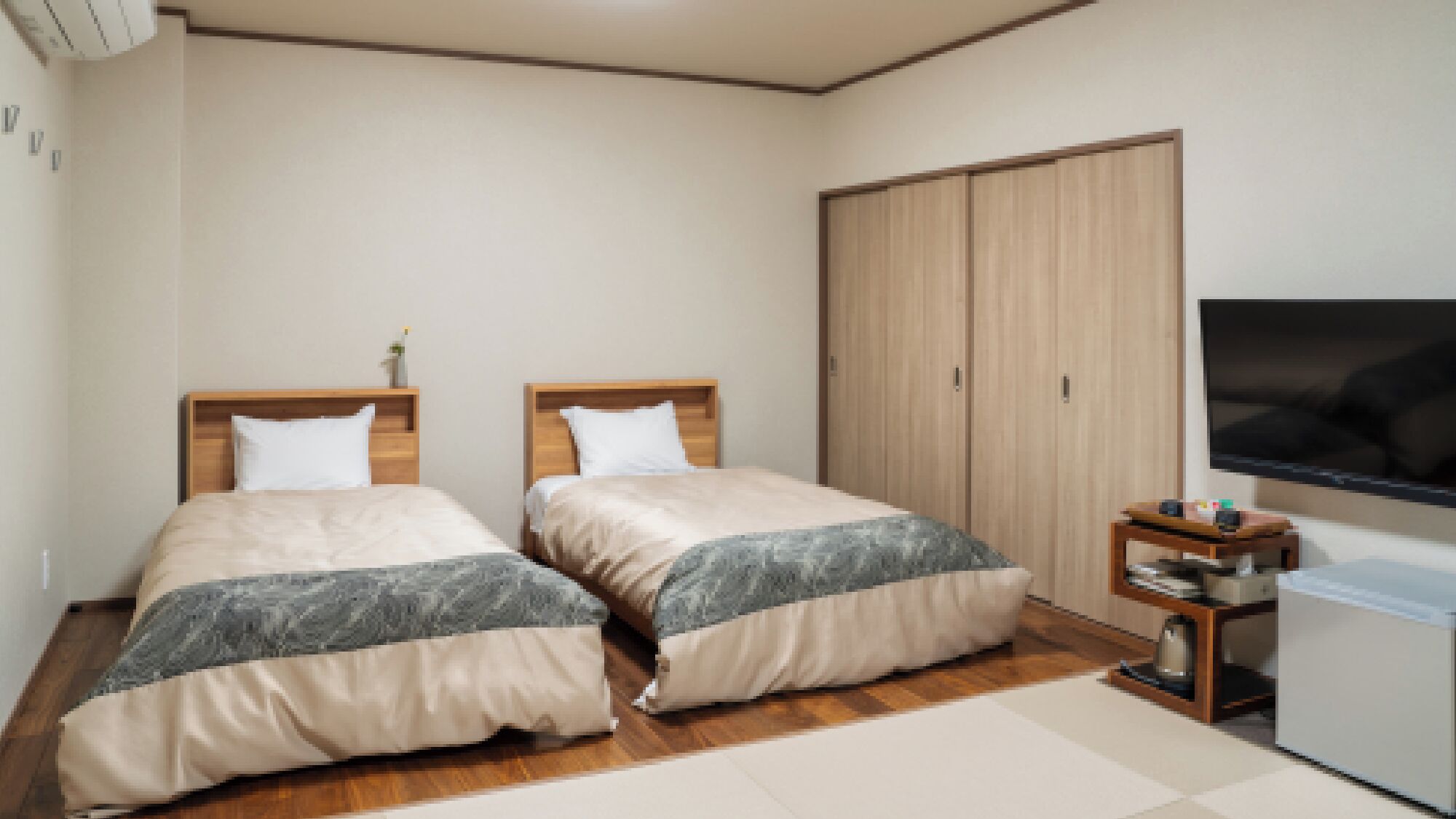 A bedroom with two beds, a wardrobe, a TV, and a small table.