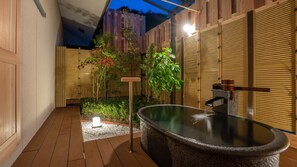 Un espace bien-être comprenant un jacuzzi, des murs en bois et une clôture en bambou.