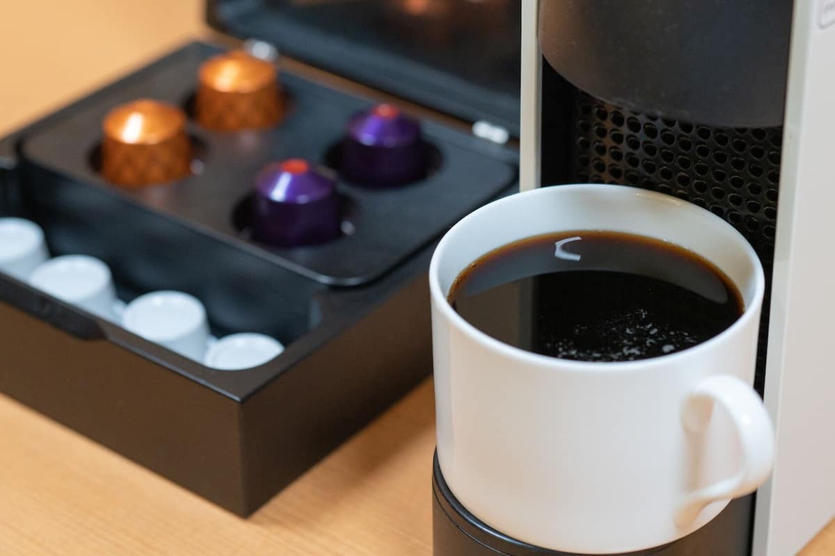 Eine Kaffeemaschine mit einer Tasse Kaffee und einer Kapselbox.