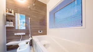 A modern bathroom with a bathtub, toilet, and shower. - Villa Hanasaku Fujikawaguchiko B (Fujikawaguchiko)