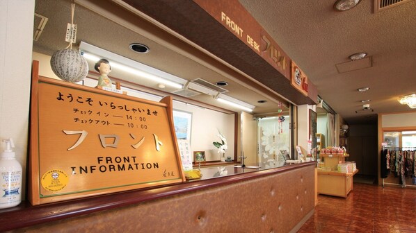 A reception desk with a wooden sign indicating 'Front Information' and a 'Doctor Water' dispenser. - Rotenburo no Yado Hanamiya (Inawashiro)