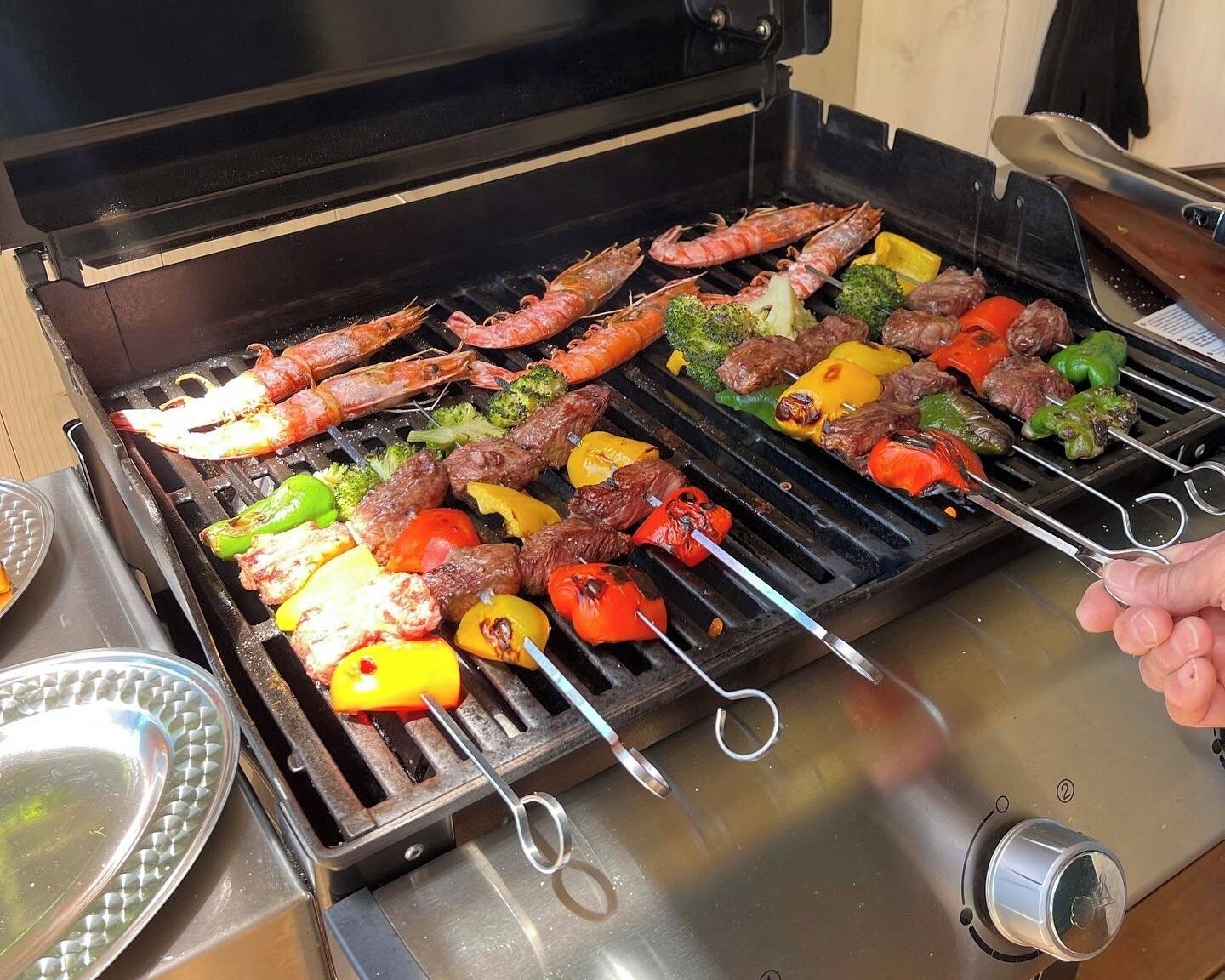 A grill with various meats and vegetables being cooked.