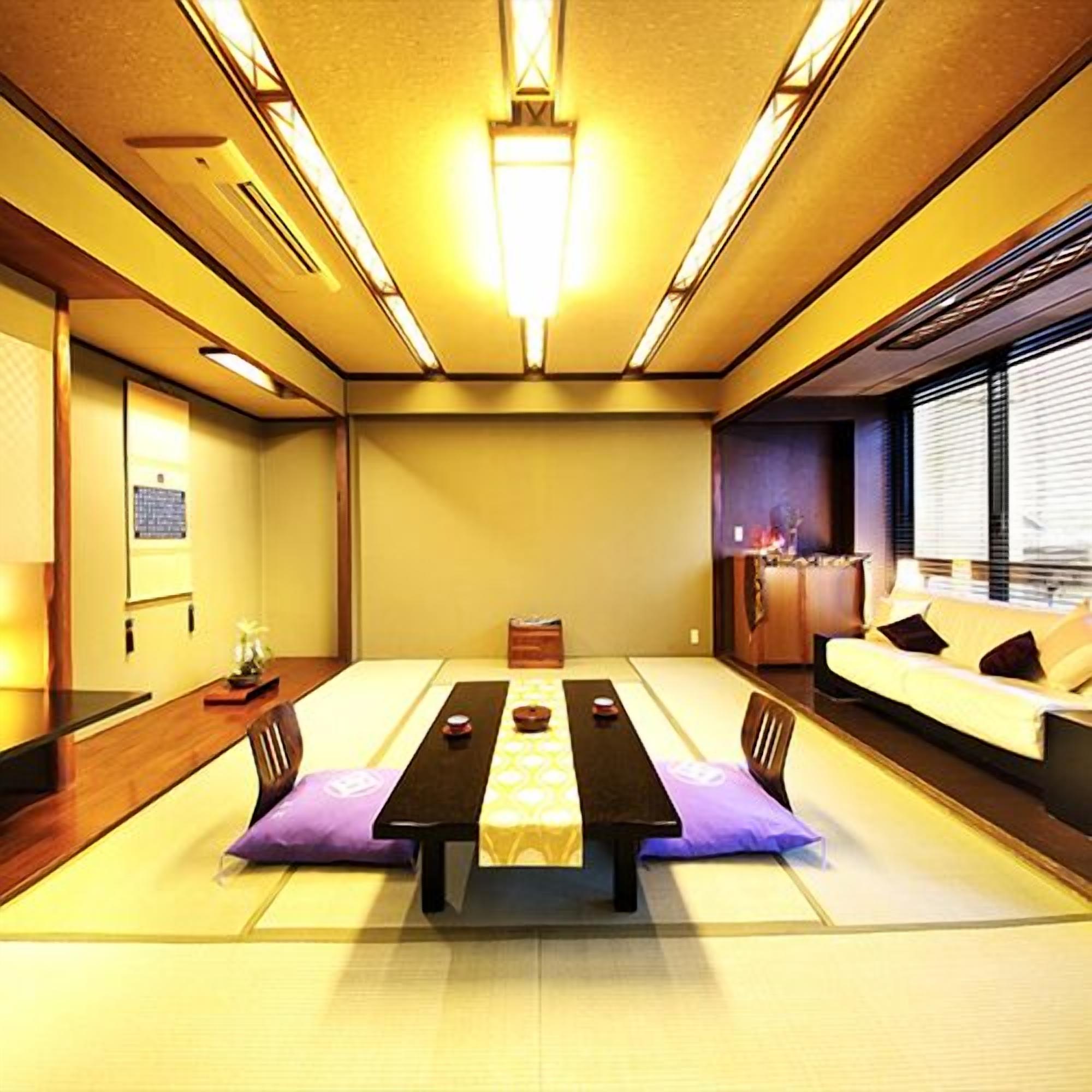 Una habitación tradicional de tatami con una mesa baja, cojines y un sofá.