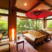 Una habitación con un conjunto de sofás, una mesa y un paraguas rojo.