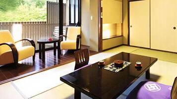 A traditional Japanese room with tatami flooring, a low table, and a sofa.