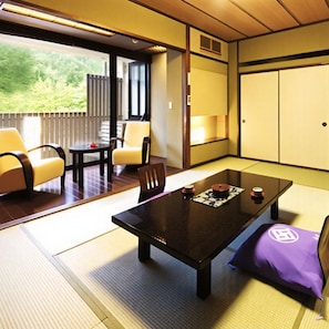 A traditional Japanese room with tatami flooring, a low table, and a sofa.