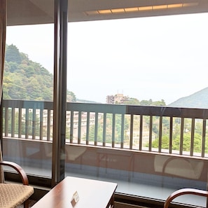 A room with a view of a mountainous landscape through large windows.
