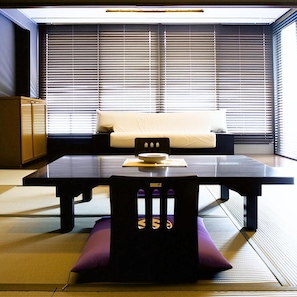 A modern interior with a sofa, a dining table, and a chair.