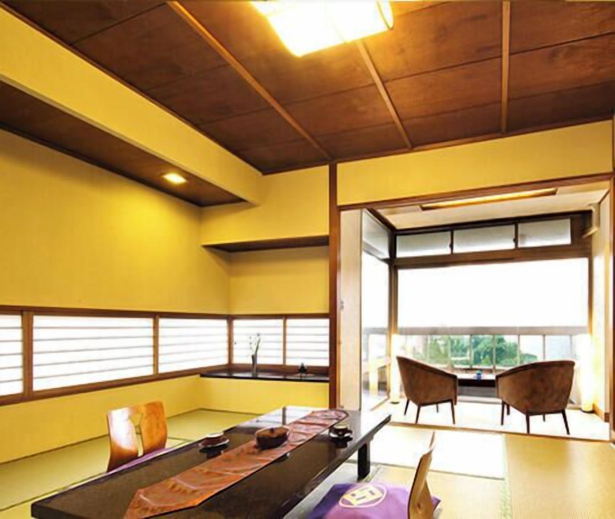 Una habitación con techo de madera, una larga mesa con sillas y vistas a través de un amplio ventanal.