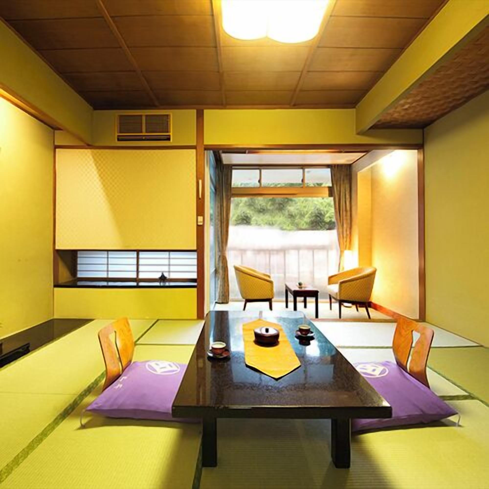 Ein traditioneller japanischer Raum mit Tatami-Böden, einem niedrigen Tisch und Schiebetüren zu einem Außenbereich.