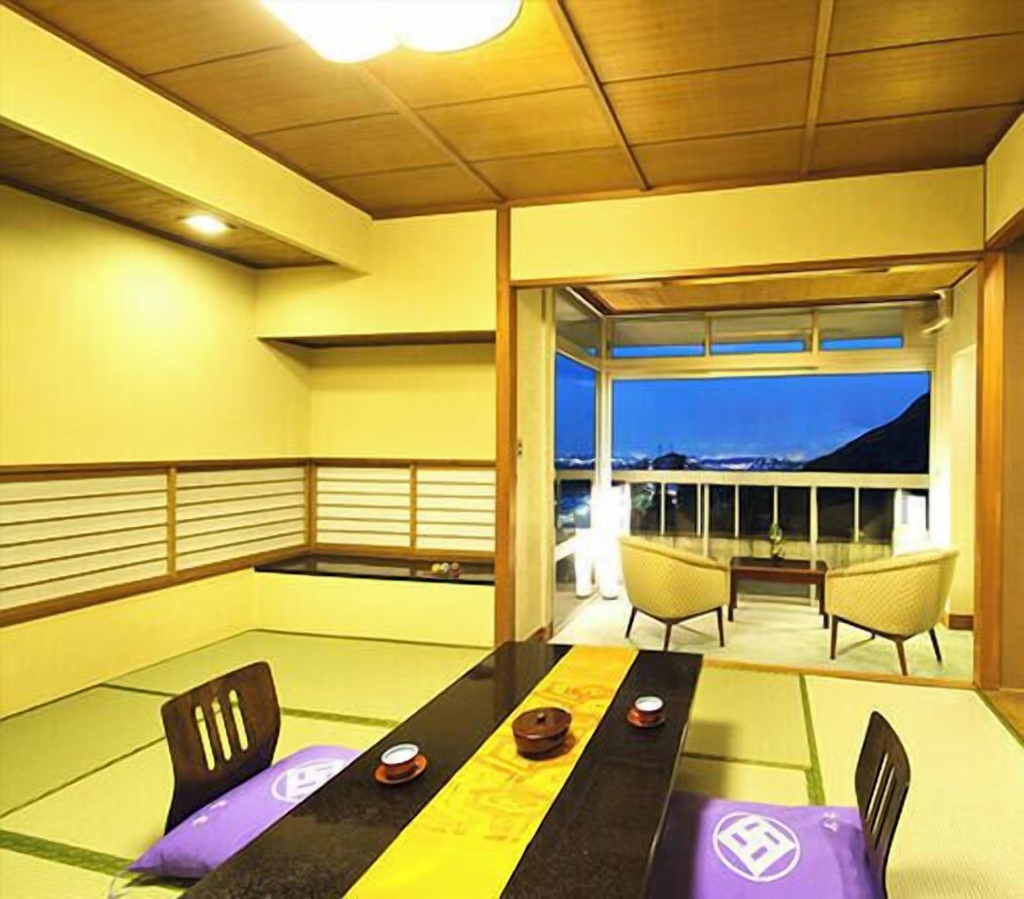 Un área de comedor con esteras de tatami, una mesa baja y sillas.