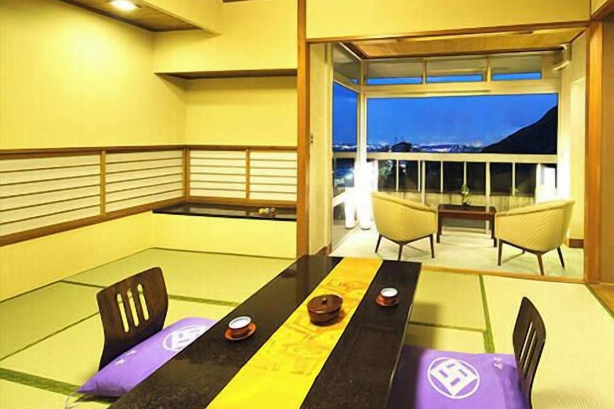 A dining area with tatami mats, a low table, and chairs.
