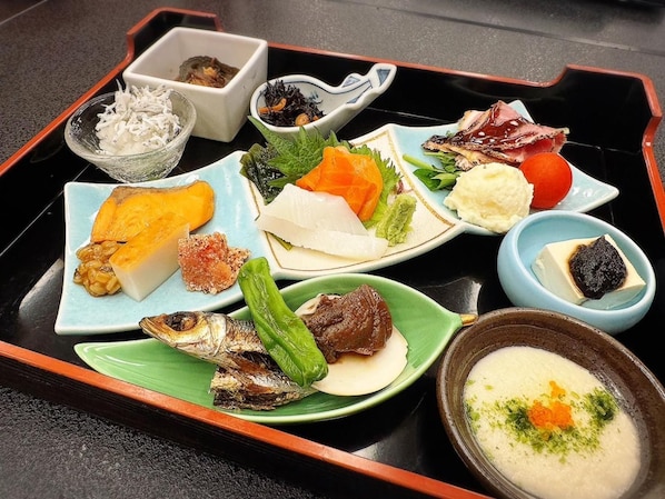 A tray with various dishes including fish, vegetables, and a bowl of soup.
