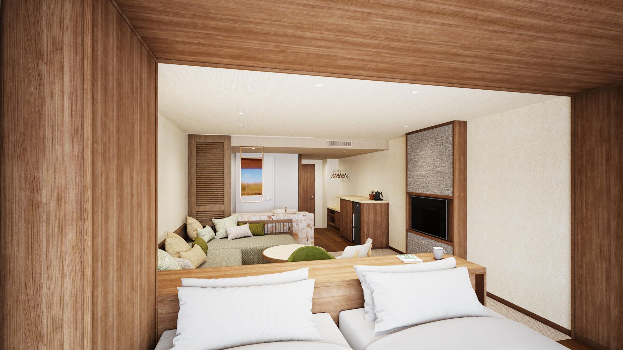 A modern hotel room with a wooden headboard, a sofa, a dining table, and a kitchen area.