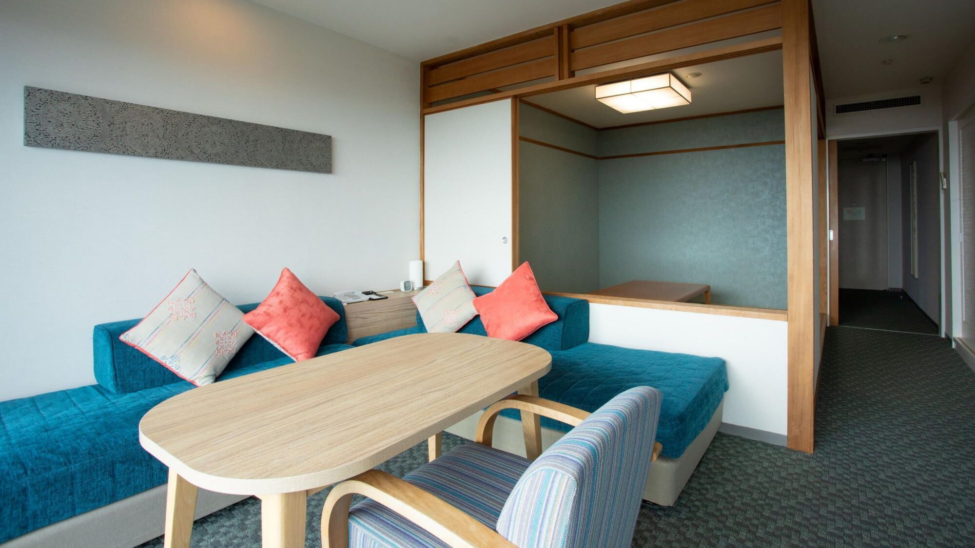 A room with a sofa, a table, and a mirror.
