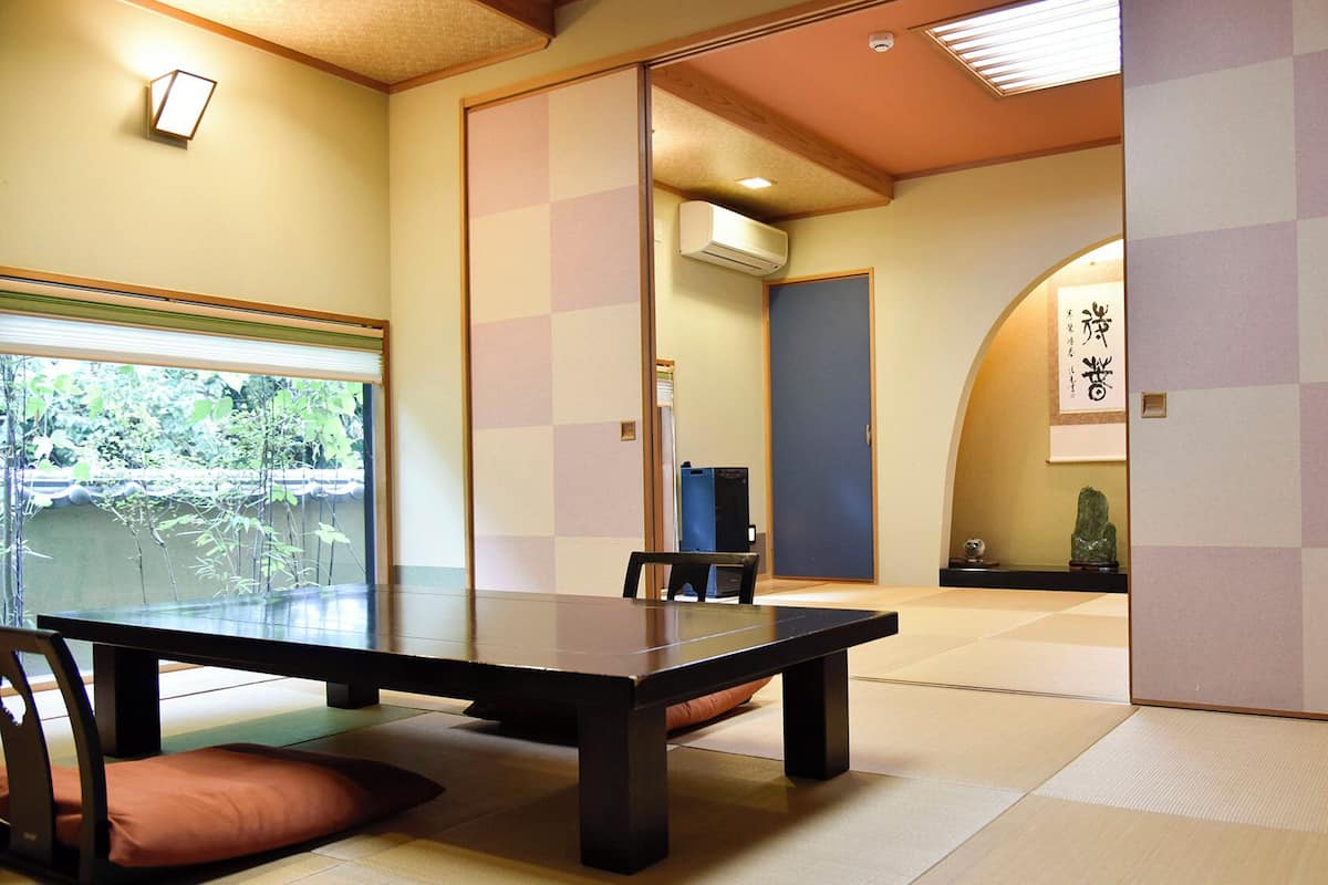 Een traditionele Japanse kamer met tatami vloerbedekking, een lage tafel en een schuifdeur.
