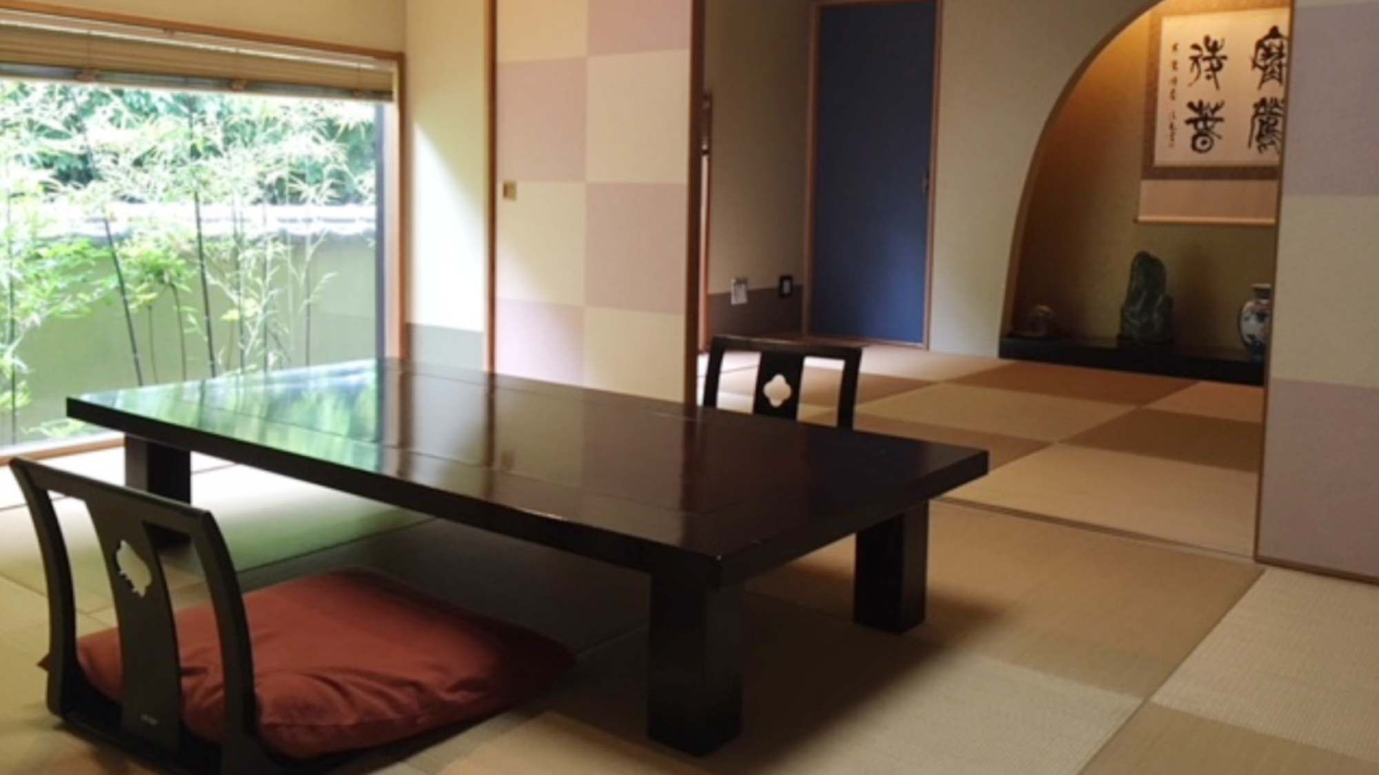 Ein traditioneller japanischer Raum mit Tatami-Boden, einem niedrigen Tisch und einer Schiebetür.
