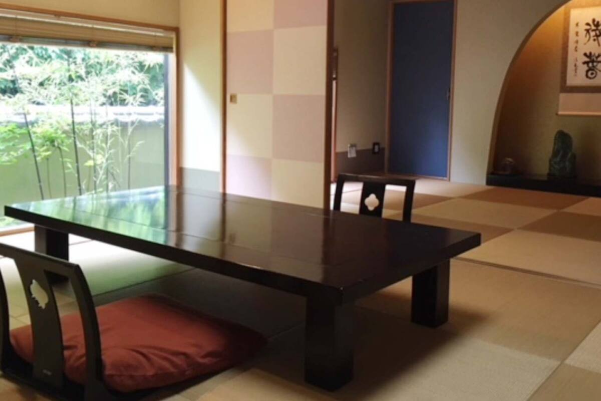 Een traditionele Japanse kamer met tatami vloerbedekking, een lage tafel en een schuifdeur.