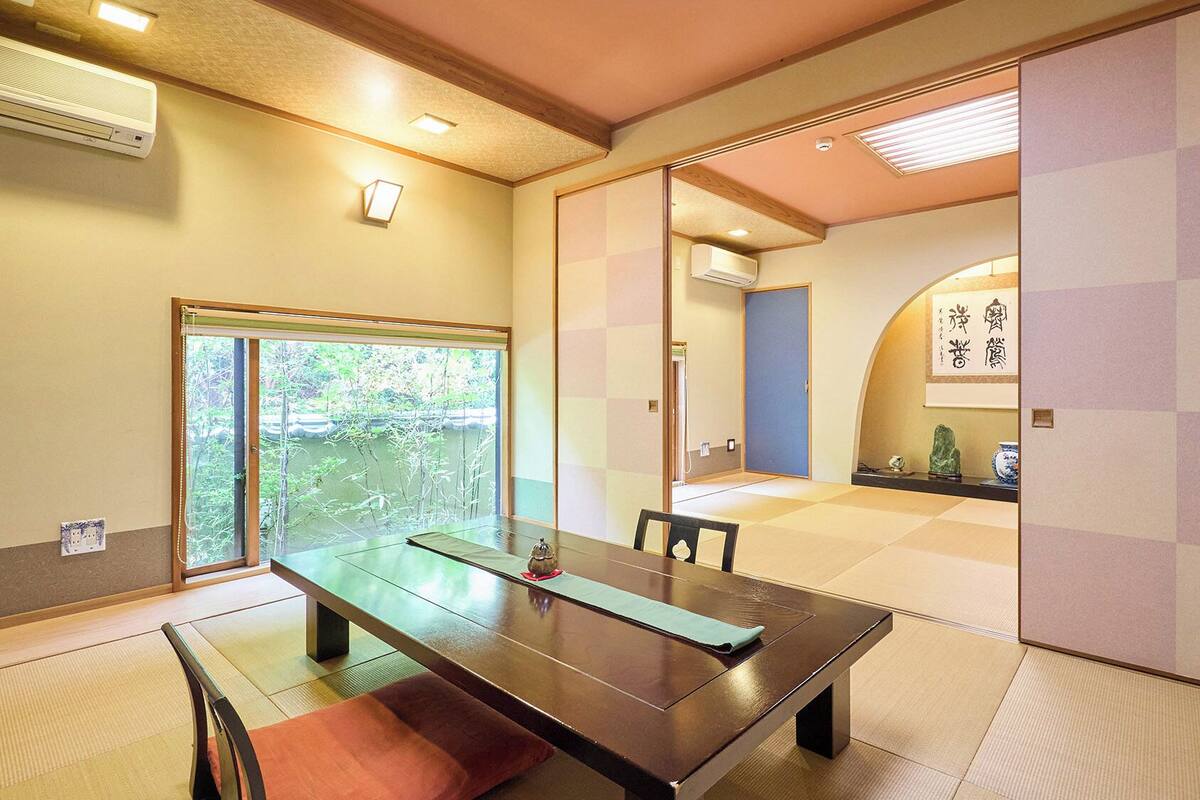 Een traditionele Japanse kamer met tatami vloerbedekking, een lage tafel en schuifdeuren.