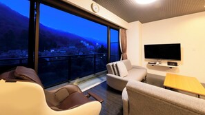 A modern hotel room with a large window, a flat-screen TV, and a massage chair. - Point Vacation Kaga Yamanaka (Kaga)