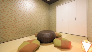 A room with tatami flooring, a woven tatami mat, and a traditional Japanese-style cabinet. - Point Vacation Kaga Yamanaka (Kaga)