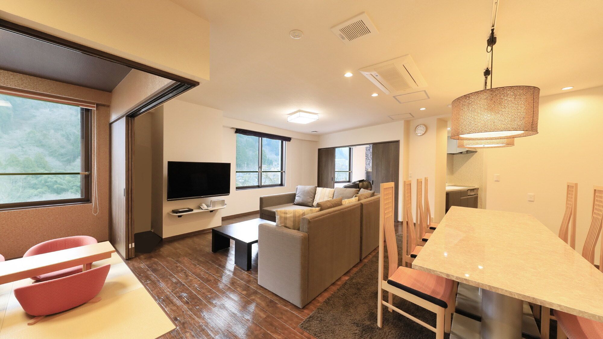 A modern living room with a TV, sofa, and dining area.