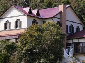 A two-story building with a red roof, white walls, and a brick chimney. - Kids Pension Fruit Juice Awajishima (Awaji)