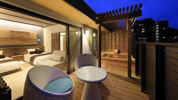 Eine moderne Sitzgruppe im Freien mit einer Couch und Stühlen, einem kleinen Tisch und einer Holzterrasse.