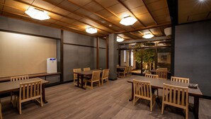 A conference room with wooden tables and chairs, a projector screen, and a small refrigerator. - Taiheian (Sakai)