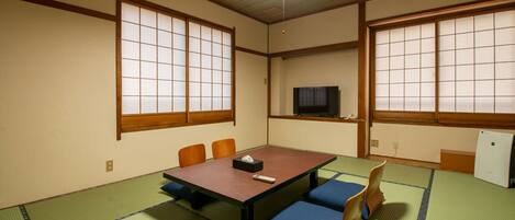 Ein traditioneller japanischer Raum mit Tatami-Böden, einem niedrigen Tisch und Schiebetüren.