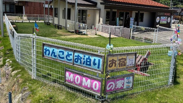 A fenced area with signs indicating a cafe and a pet-friendly establishment.