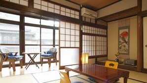 A traditional Japanese room with tatami flooring, a low table, and chairs. - Tsurumisou (Arita)