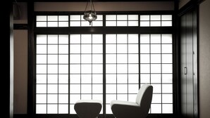 A room with a traditional Japanese-style sliding door, a hanging light fixture, and two chairs. - Tsurumisou (Arita)