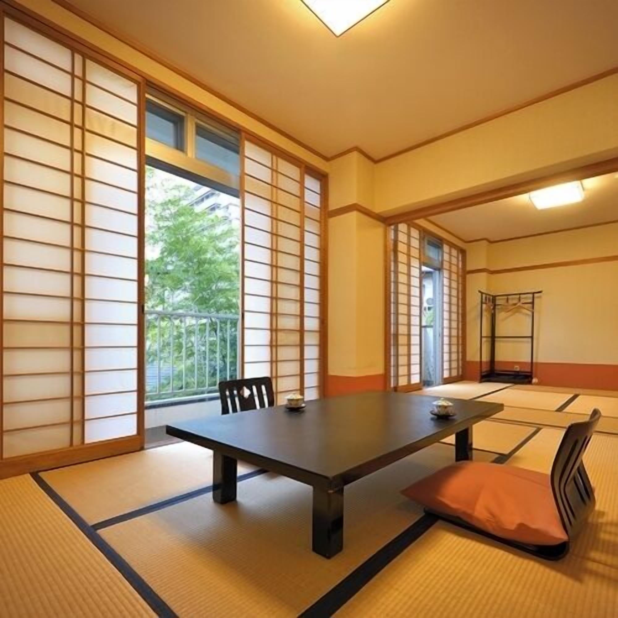 A traditional Japanese room with tatami flooring, a low table, and sliding doors.