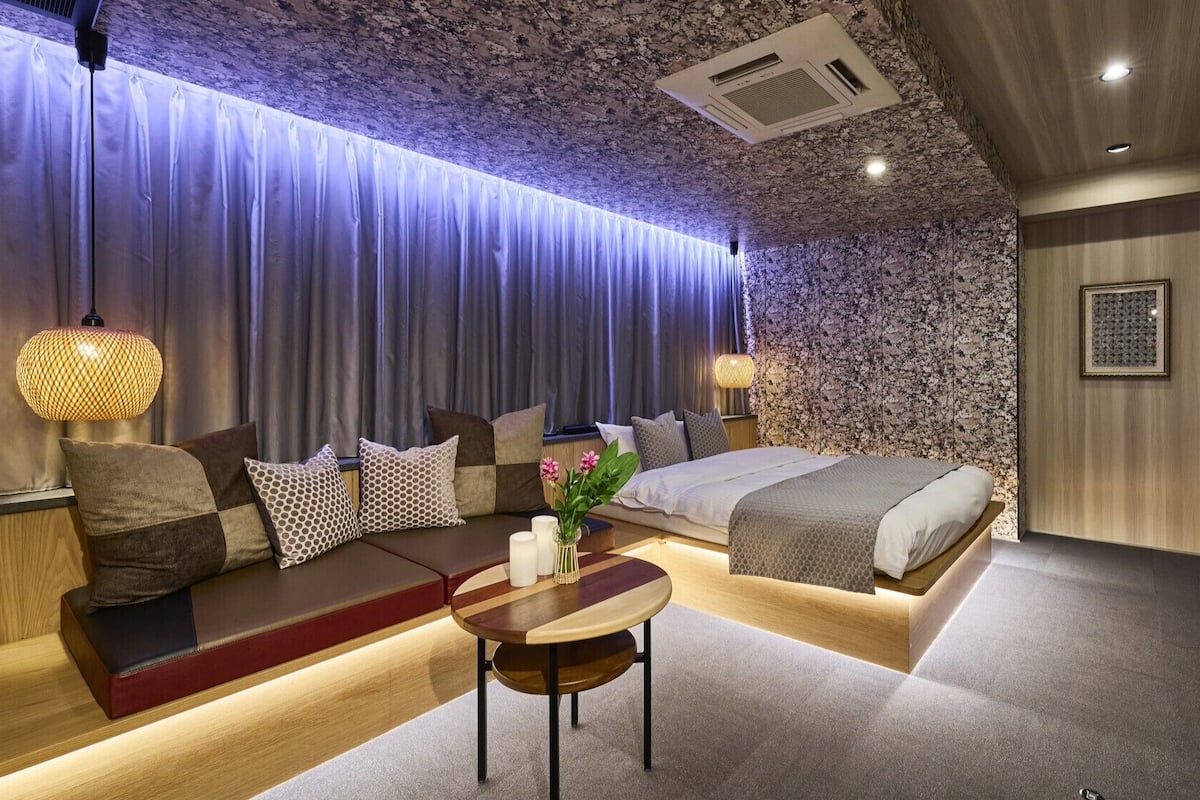 Un dormitorio moderno con cama, zona de estar y televisor.