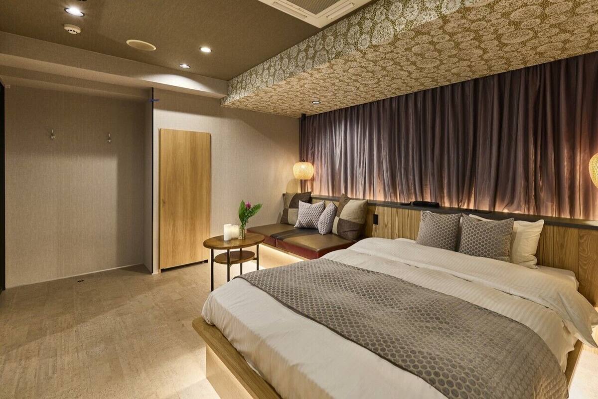 Un dormitorio moderno con una cama grande, una mesita de noche, una lámpara y un techo con diseño.