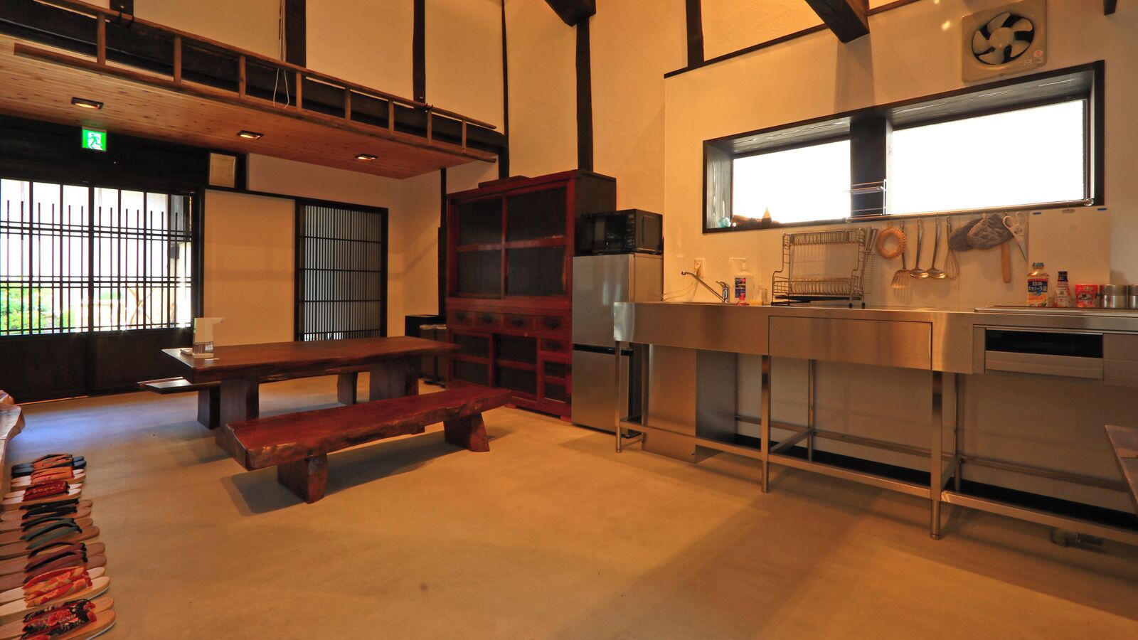 Una cocina con un banco de madera, un lavamanos de acero inoxidable y un microondas.