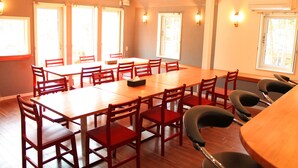 A conference room with a long table and multiple chairs, large windows, and wall-mounted lights. - Aya no Yado Fusen (Shirahama)
