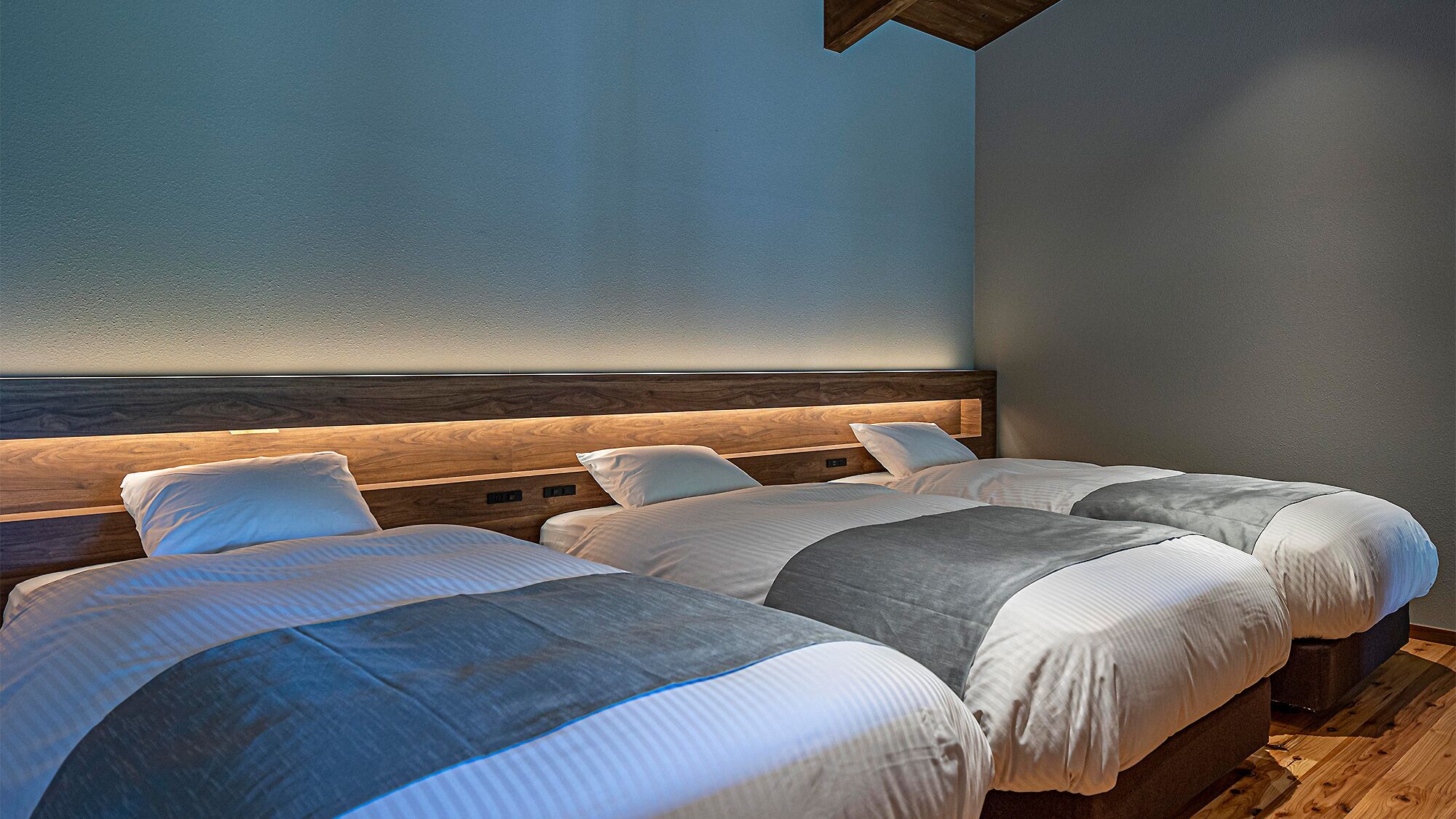 Habitación de hotel con una cama grande, cabecero de madera y un diseño sencillo y limpio.