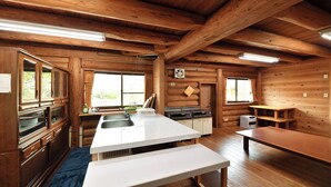 Une cuisine de style rustique, avec des murs en bois, une grande fenêtre et un coin repas.