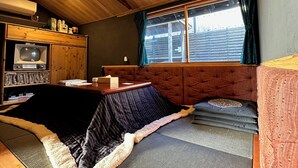 Ein gemütliches Wohnmobil-Interieur mit einem Bett, einem kleinen Tisch, einem Fernseher und einem Bücherregal.
