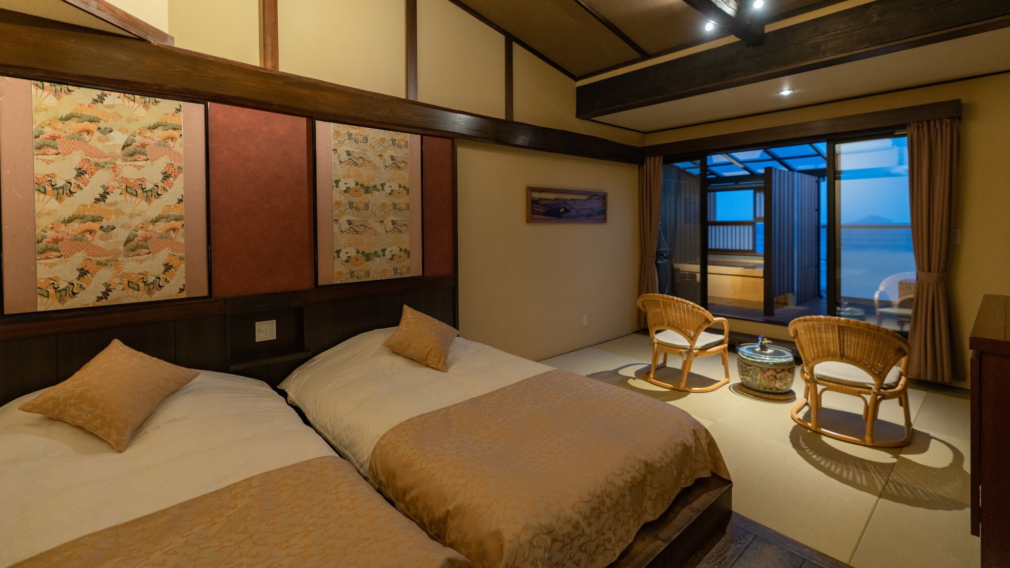 A hotel room with two beds, a balcony with a view, and traditional decor.