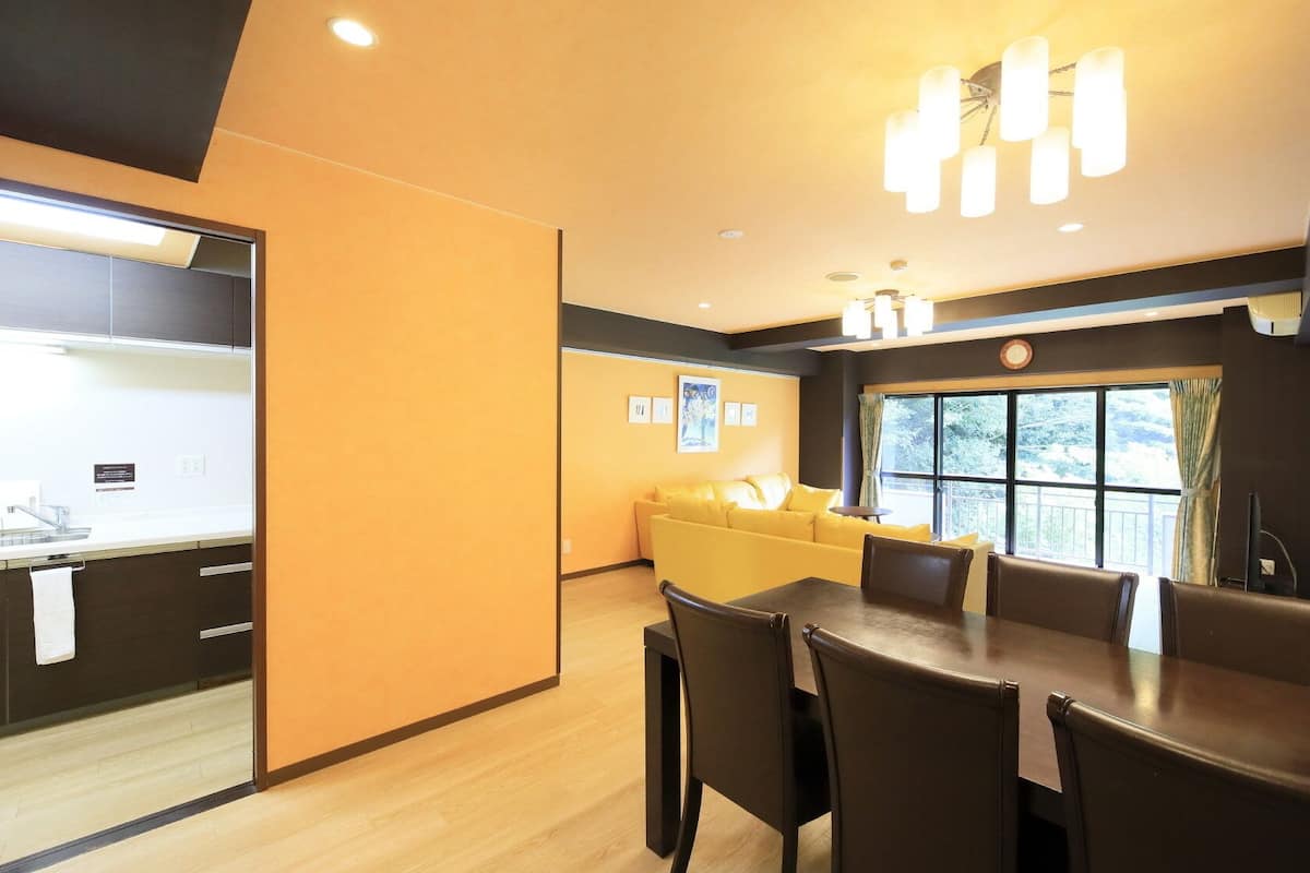 Une chambre d’hôtel moderne avec un coin repas, un canapé et une grande fenêtre.
