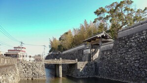 A stone bridge over a waterway, a traditional wooden structure, and a stone wall. - Goto Guesthouse Sakiyama Hills (Goto)