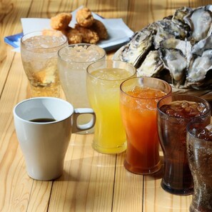A wooden table with drinks, a coffee cup, and a plate of food. - Wood Design Park Yoi (Toyooka)