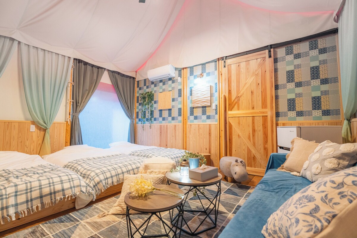 A cozy room with two beds, a small table, and a couch.