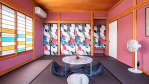 A traditional Japanese room with tatami flooring, a low table, and a sliding door with a floral pattern. - Maigre Yebisu (Sado)