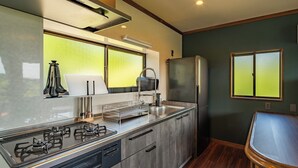 A compact kitchen with a gas stove, a sink, and a refrigerator. - Maigre Yebisu (Sado)