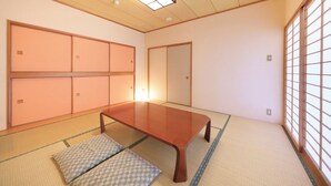 A traditional Japanese room with tatami flooring, a low wooden table, sliding doors, and a view through a shoji screen. - Point Vacation Izu Kogen (Ito)